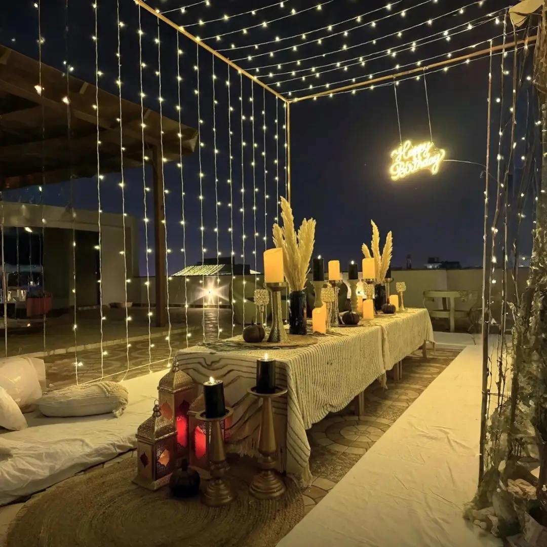 Rooftop setup with fairy lights, candles and a Happy Birthday neon sign
